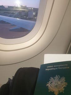 passeport devant un hublot à l'intérieur de l'avion